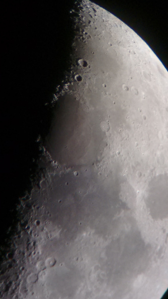 The moon taken with a mobile phone camera through the eye piece of a telescope